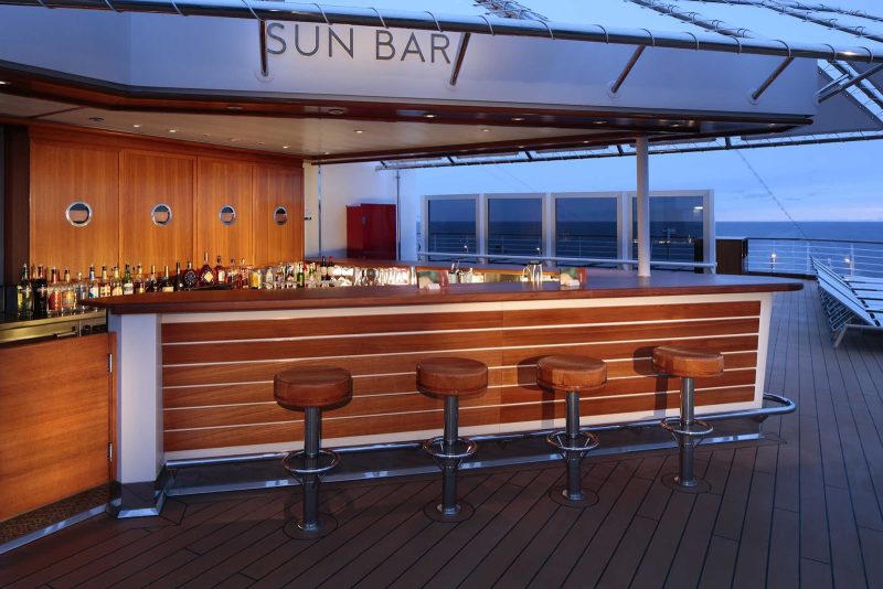 Grab a cocktail and soak in the views on deck from the Sun Bar on ms Koningsdam.