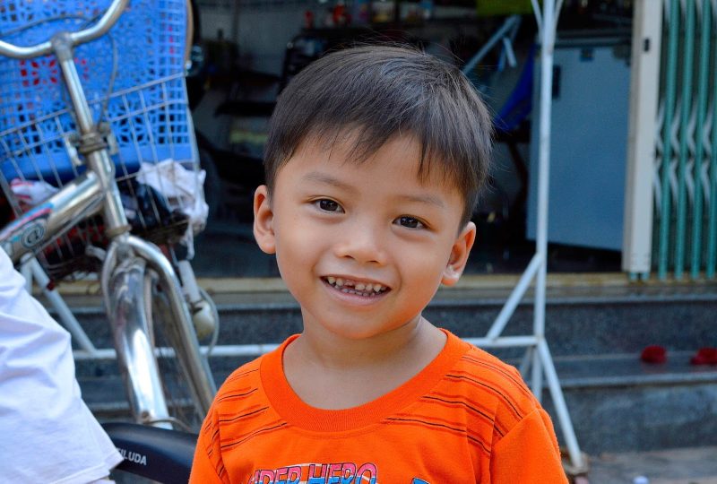 A young boy very happy to see Western tourists visit his village in Vietnam.