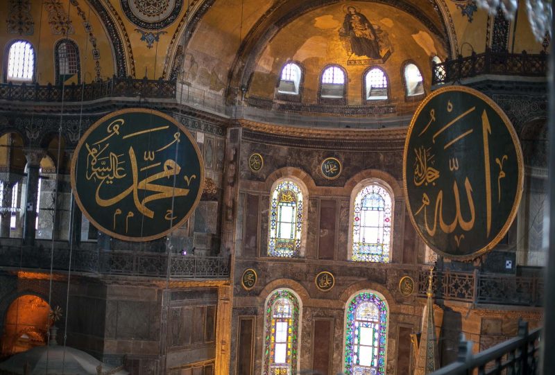 Second-story view of magnificent hand-painted signage with sayings from the Koran adorn the walls of Hagia Sophia in Istanbul.
