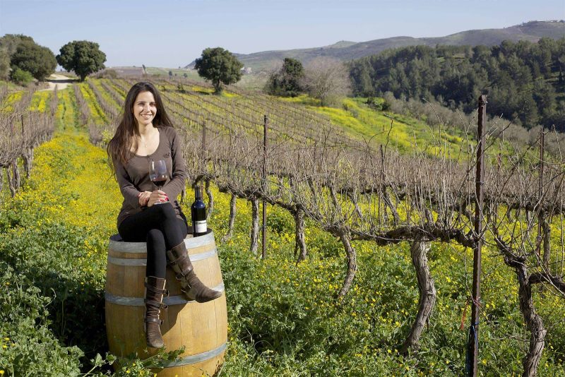A woman kicks back amid the vineyards of a winery in Israel.