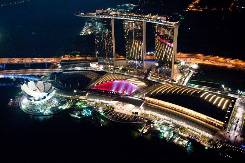 The three-building Bay South Garden Financial center on the coast of Singapore glitters at night.