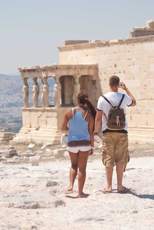 Visitors observe the Porch of the Caryatids on the Acropolis in Athens during a Lindblad Expeditions walking tour.