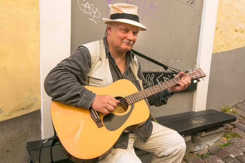 A street musician pauses for a visitor in Old Tallinn.