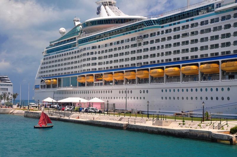 Opposites attract: a tiny dinghy next to the mega cruise ship Explorer of the Seas.
