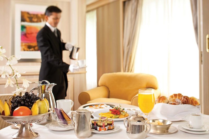 A butler provides breakfast for guests in their suite during a Silversea voyage.