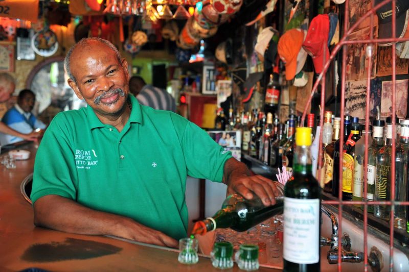 Jesus M.E "Chu" Zimmerman, proprietor of the Notto Bar in Willemstad, Curacao, pours shots of the famous Ròm Bèrdè, a house-made green rum.