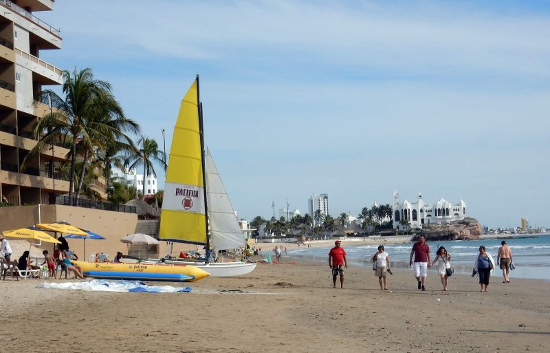 A sailboat and banana boat rest on the beach of Mazatlan, Mexico.