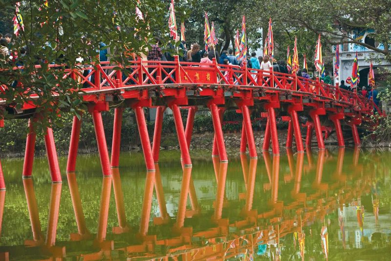 Locals cross a picturesque bridge in Hanoi, Vietnam, during a Uniworld cruise in River Orchid.