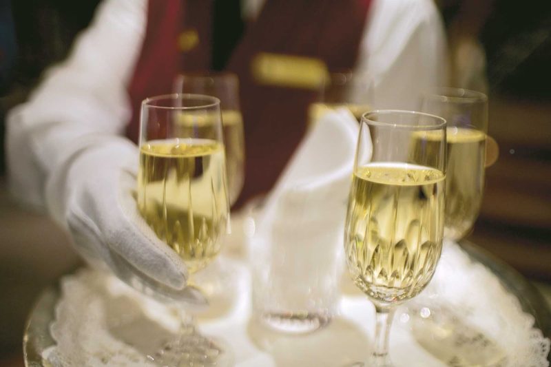 A butler serves Champagne during a Regent Seven Seas sailing.