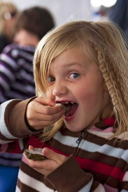 A young girl enjoys shellfish at the annual Shellfish Festival in Charlottetown, Prince Edward Island, Canada.