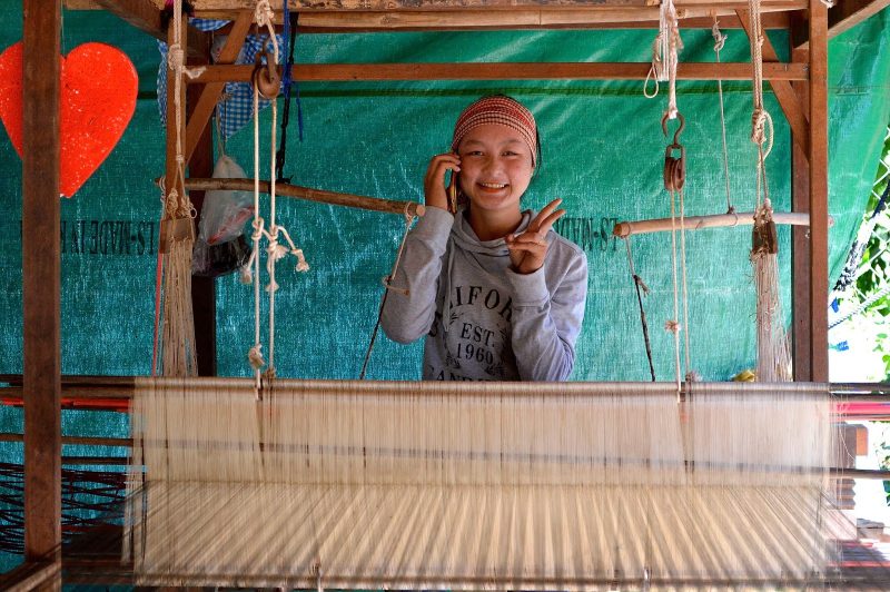 A girl gestures in a silk weaving cooperative originally set up for war widows.