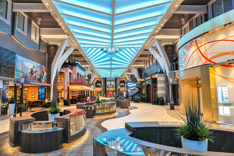 Follow the checkered floor of the Royal Promenade to see artworks, grab a brew at Copper & Kettle (left) or a bite at Sorrento's (right) on Symphony of the Seas.