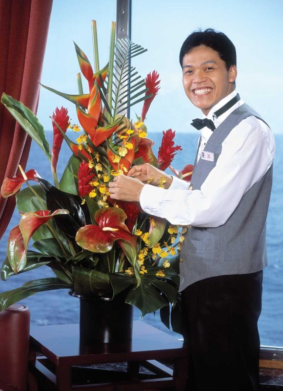A butler prepares a floral arrangement in a suite in The Haven on Norwegian Cruise Line.