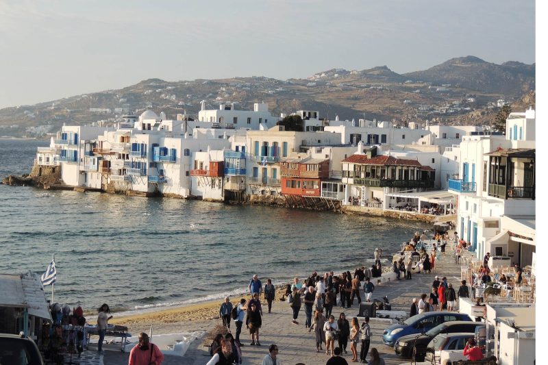Cruise ship passengers begin to make their way along the waterfront in Mykonos, Greece.