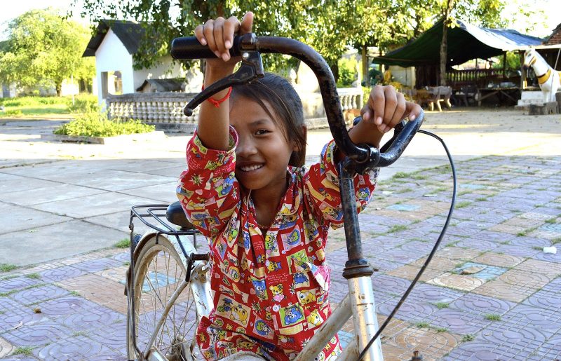 A shy girl on a bike in Vietnam was still very interested in meeting Western tourists.