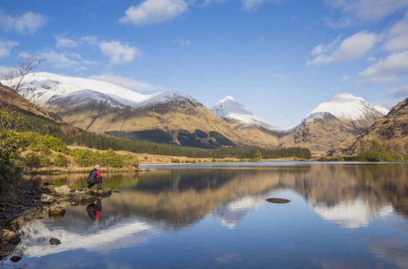 Lochan Urr in Glen Etive with a snow-capped Buachaille Etive Beag and Buachaille Etive Mor in the background in western Scotland.