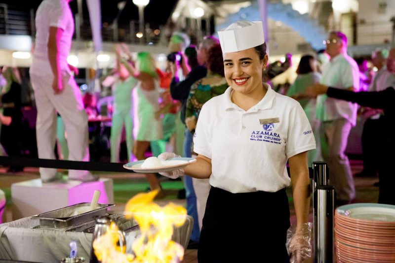 An Azamara Club Cruises crew member serves up a dish during a White Night party.