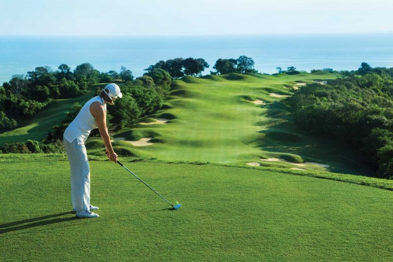Seeing green: A woman is about to tee off on a golf course hugging the Jamaican coast.