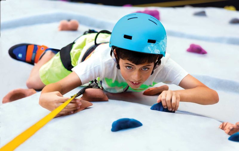 A kid tests his rock-climbing skills on Harmony of the Seas.