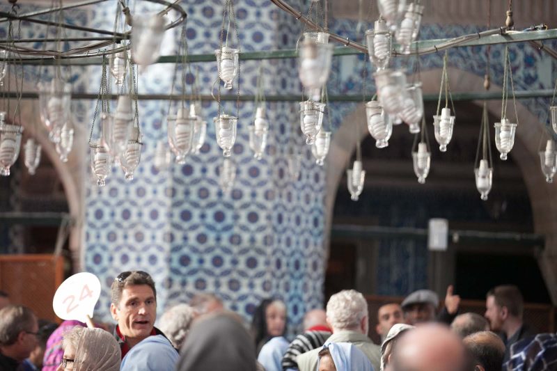 A tour guide gathers his group at Rüstem Pasha Mosque in Istanbul.