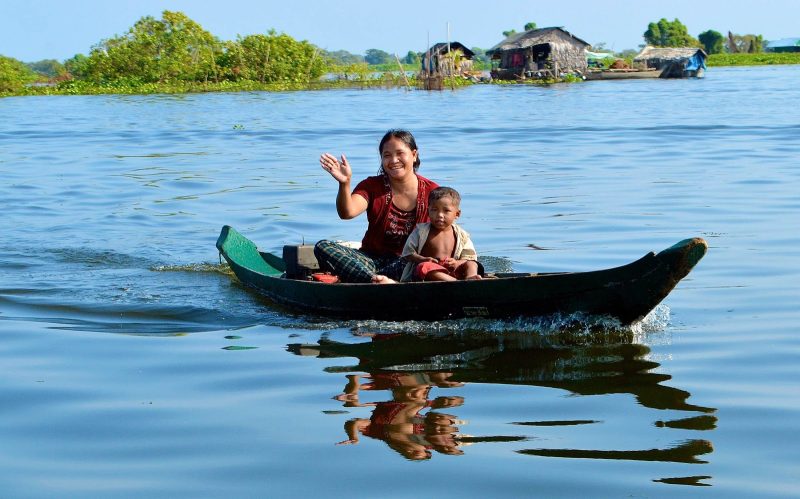 A mother and her son head to the local school in a flat bottom boat in Vietnam. 