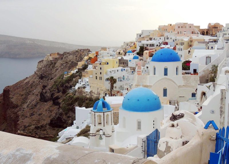 Houses and churches in the traditional colors of the Cyclades on Santorini, Greece.
