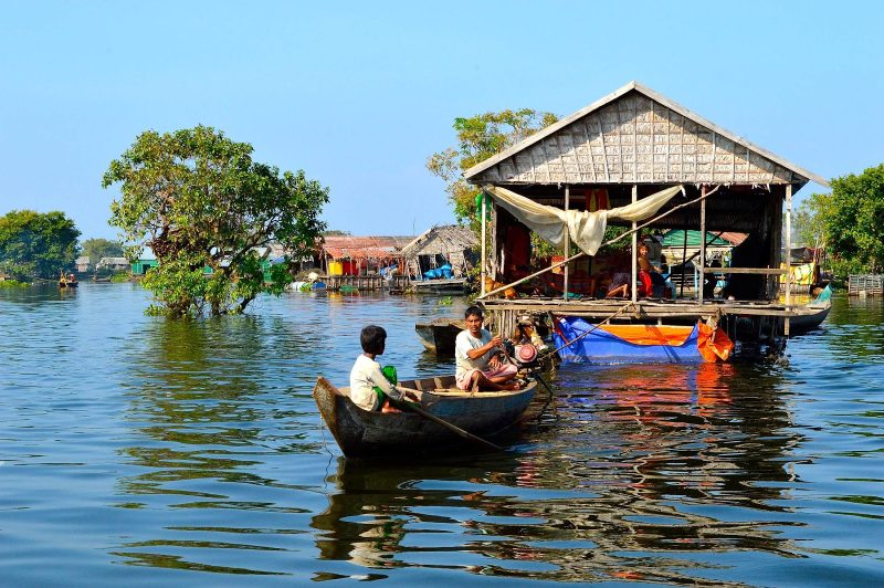 A canoe approaching a building in Vietnam. It's a traditional way of moving around the floating villages.