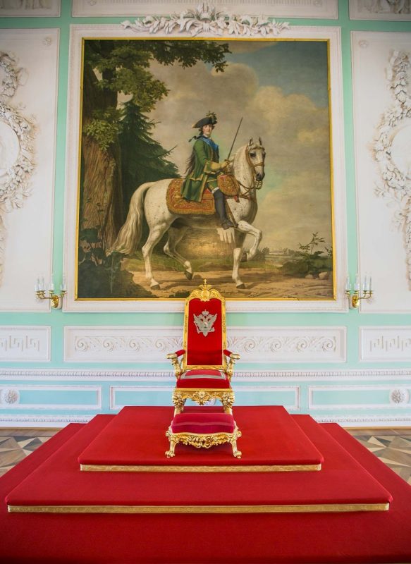 The east wall of Peterhof Palace’s Throne Room displays the chair of state placed on a dais beneath the portrait “Catherine II on Her Horse Brilliant.”