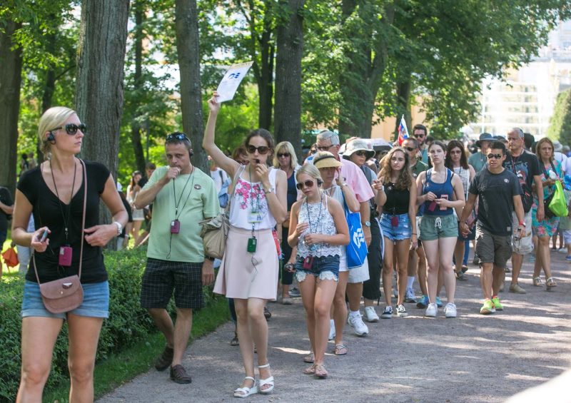 A tour leader takes her group through the grounds of Peterhof Palace near St. Petersburg, Russia.