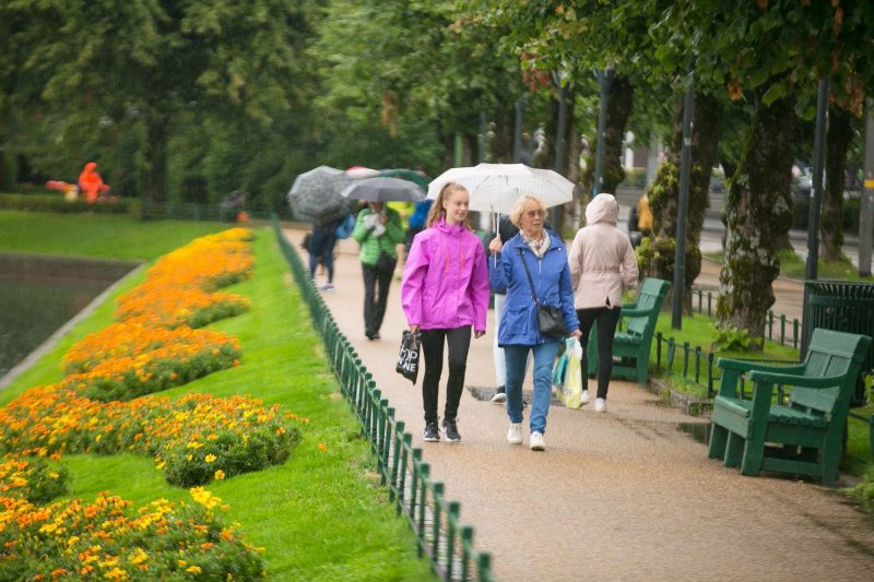 Pedestrians walk along the enclosed lake Lille Lungegardsvannet in Bergen, Norway. 