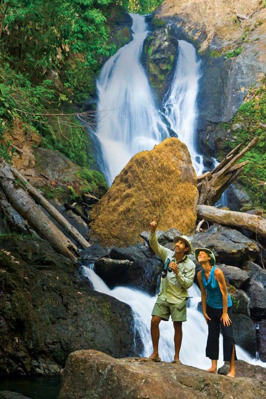 Naturalist guide Jose Calvos and wellness specialist Becky Timbers stop by a waterfall in Corcovado National Park, Costa Rica.