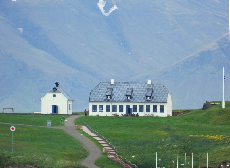 Buildings dwarfed by majestic mountains.