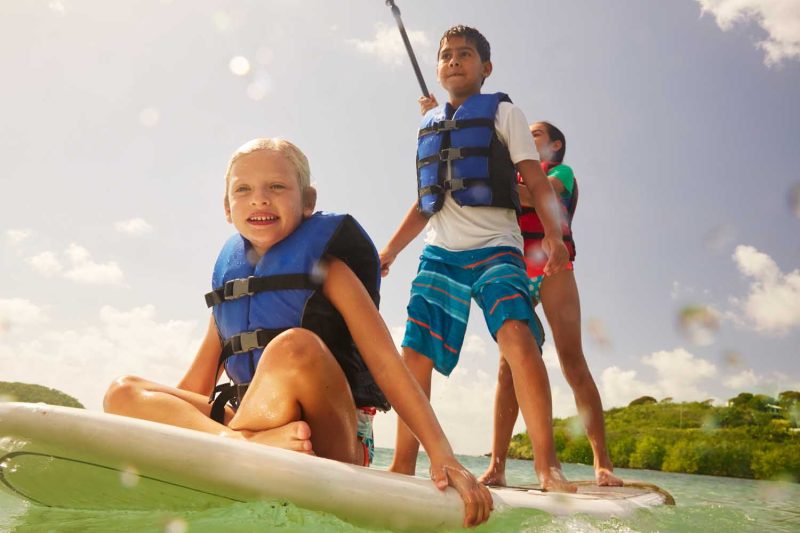 Kids can explore beaches and bays by paddleboard during your Carnival cruise.
