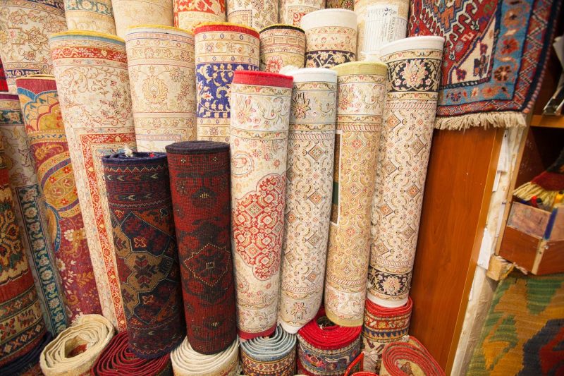 An assortment of Turkish carpets with intricate patterns at the Grand Bazaar in Istanbul.