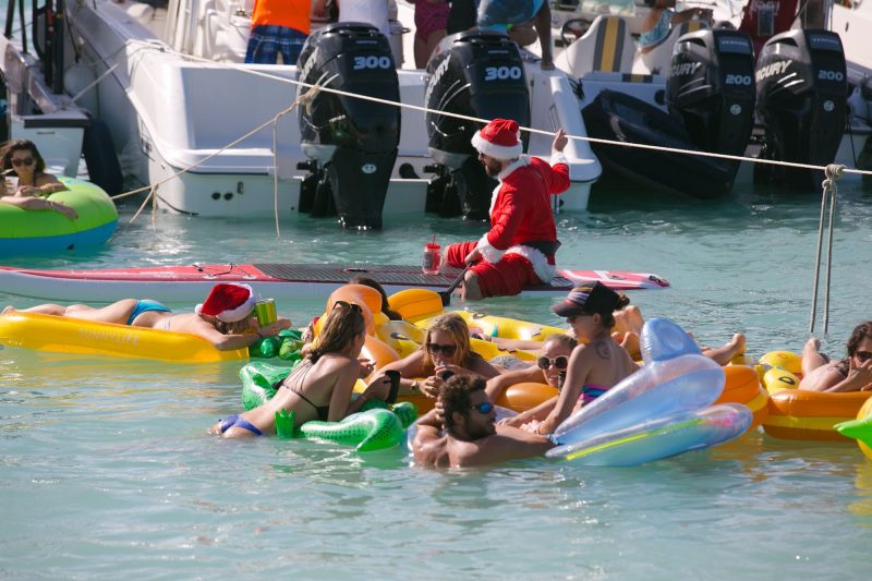 Santa Claus joins a boat party in Antigua by paddleboard.