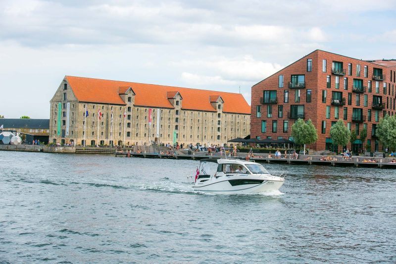 A tour boat slices through the canal separating the Christianshavn and Nyhavn sections of Copenhagen.