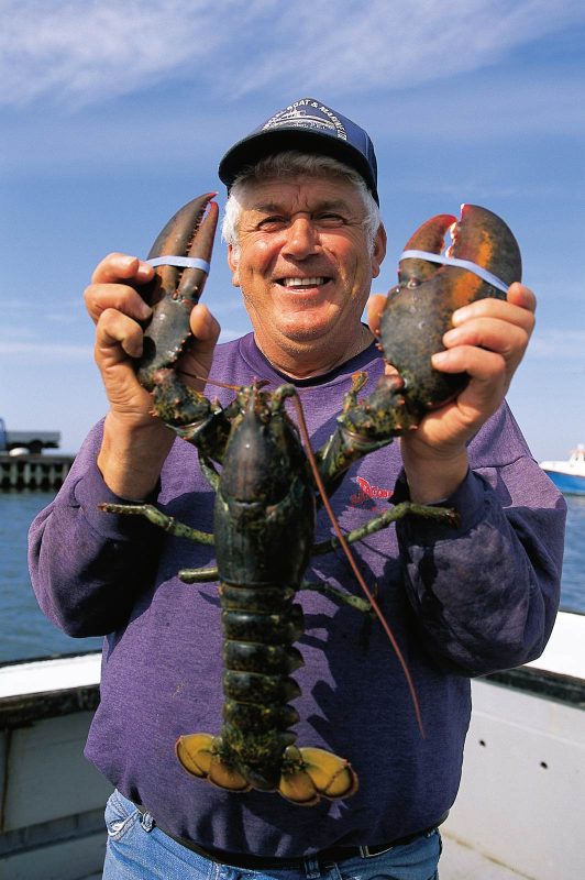 A lobster fisherman from Abrams Village, population 266, shows off his catch on Prince Edward Island, Canada.