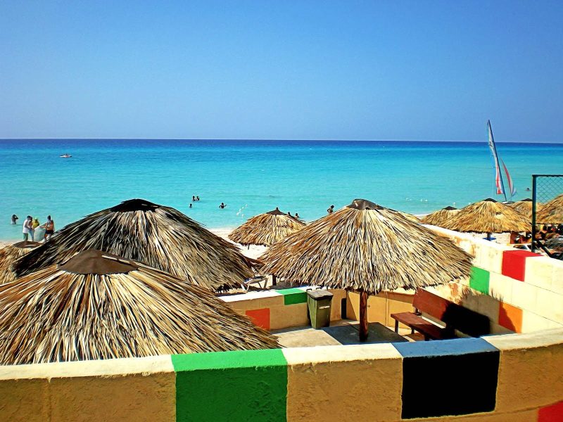 Palapas line the beach on a sunny day in Varadero, a popular beach resort town in Cuba.