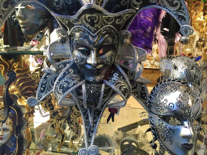 A jester's mask in a shop window along the Procuratie Vecchie on Piazza San Marco, Venice.