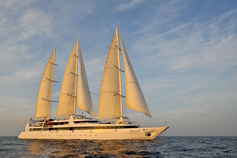The small masted luxury cruise ship Le Ponant sailing in the Maldives at sunset. 
