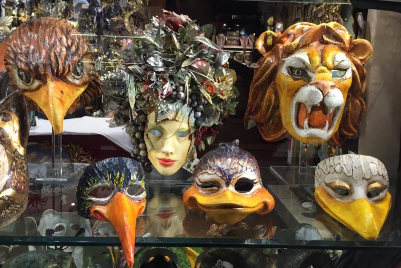 Traditional Venetian masks in a shop window along the Procuratie Vecchie on Piazza San Marco, Venice.