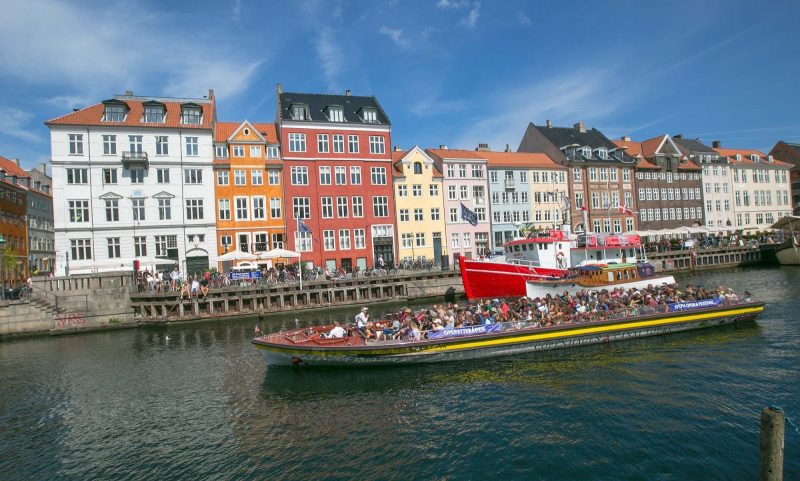 Visitors on a canal cruise pass through the Nyhavn neighborhood of Copenhagen.