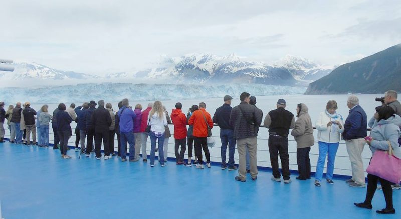 Passengers press against the rails to take in Hubbard Glacier.