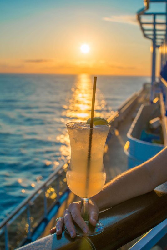 Enjoy a tall, cool drink while you watch the sunset on Carnival Vista.