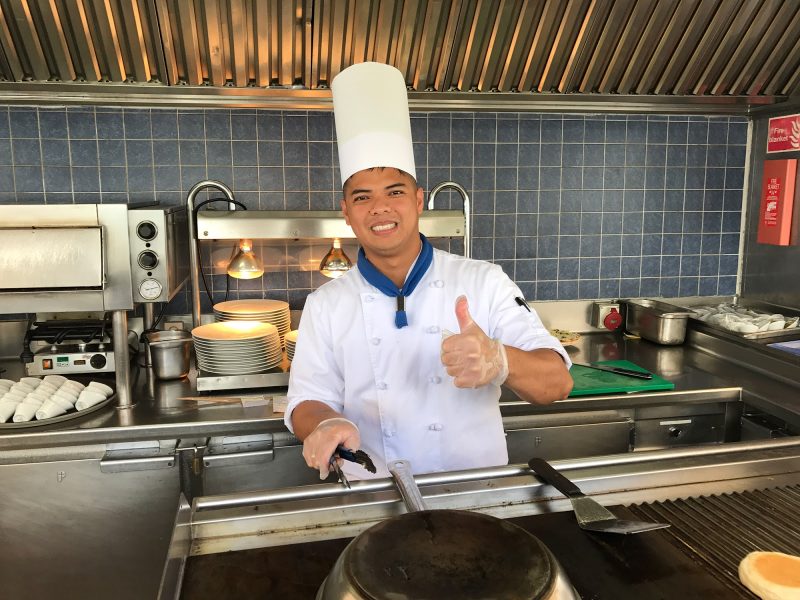 A cook at the Grill, part of the open-air Veranda on Wind Surf.