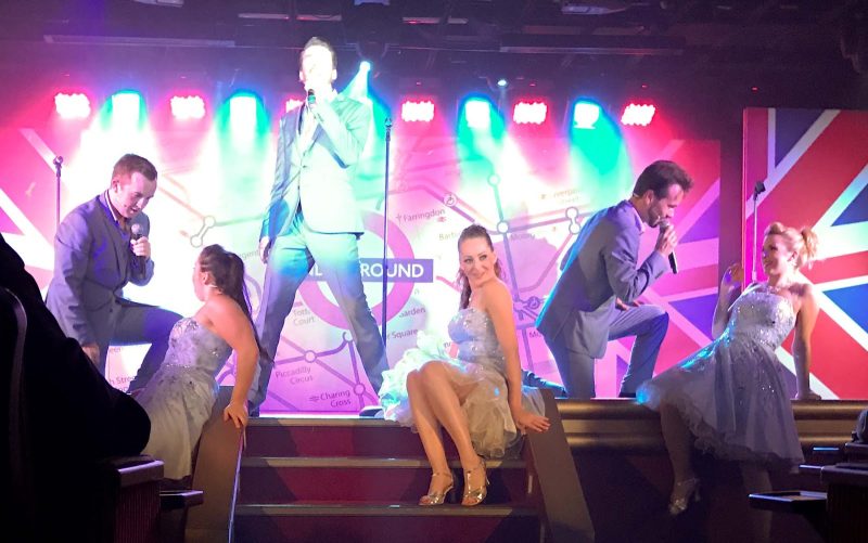 A theatrical group performs a British Invasion musical revue on Silver Spirit.