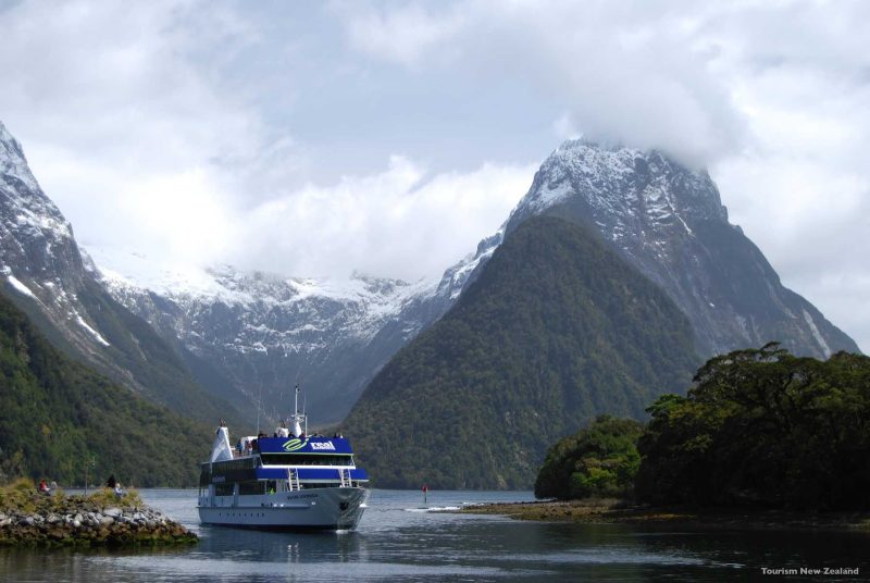At Milford Sound the landscape has an almost palpable spirit. Carved by ancient glaciers, these steep-sided fjords dwarf the boats that cruise their deep, clear waters. High above you can see hanging valleys, their ends sliced off by a passing glacier, release giant waterfalls down the walls of the fjord to the sea below.