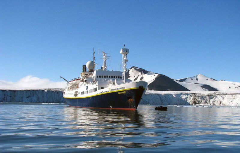 A tiny Zodiac sidles up to National Geographic Endeavor in Svalbard, the rugged region north of mainland Norway.