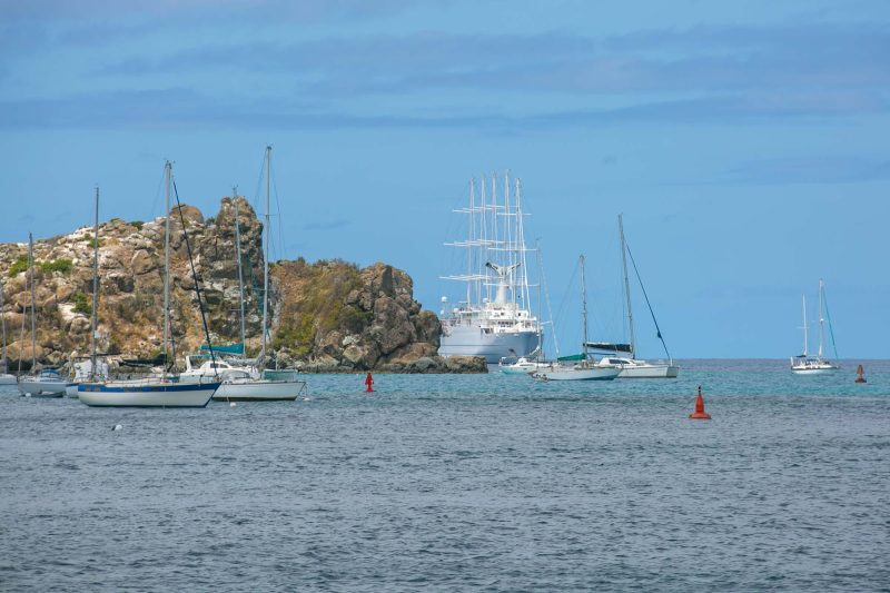 Wind Surf peeks out from behind a rock outcropping in Gustavia Habour, St. Barts.