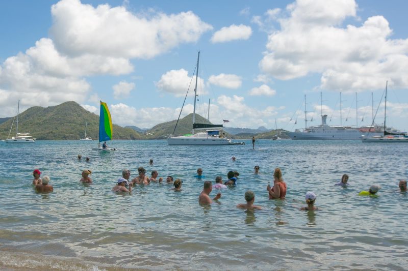 Windstar passengers loll in the placid waters of Pigeon Island, St. Lucia, during a beach barbecue.